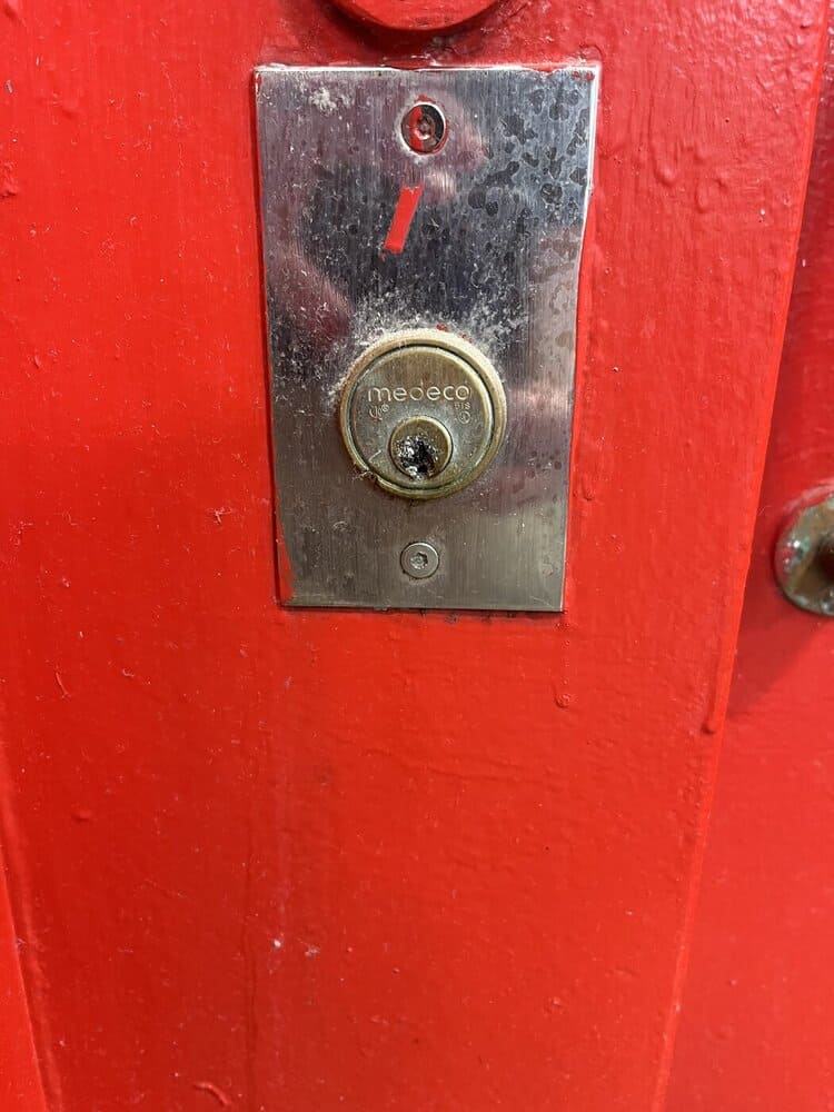 Damaged key cylinder on an interior fire exit door at Ware State Prison, state inspection photograph, August 24, 2026