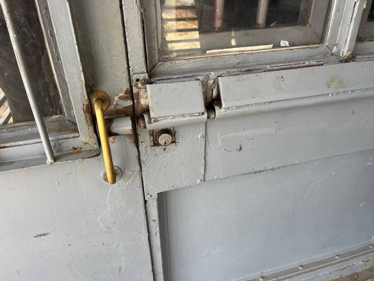 Large slide bolt on a dorm main entrance and exit door at Ware State Prison, photographed by state inspectors on August 24, 2026